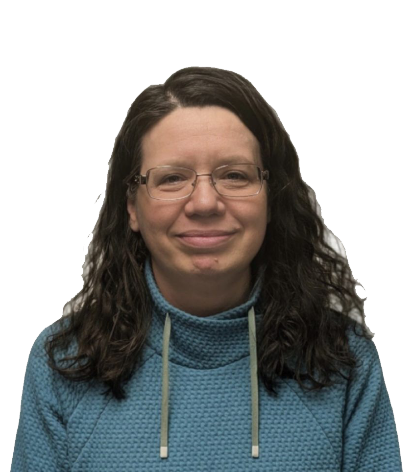 A person with long dark hair and glasses is wearing a blue sweater against a gray background.
